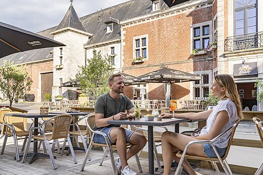 Belebte Terrasse des Schlosses Oteppe, historischer Ort nahe dem Campingplatz.