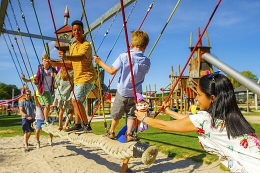 Kinder spielen auf einer Seilspielstruktur auf dem Campingplatz CAPFUN Hirondelle in Oteppe.