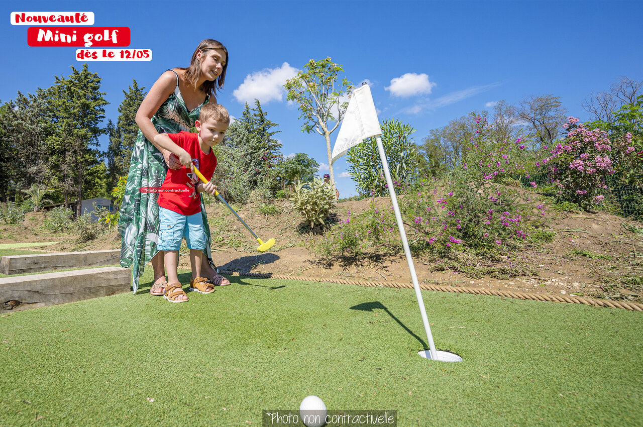 Kind und Frau spielen Minigolf auf dem Campingplatz CAPFUN Huttes in Saint-Denis d'Ol�ron.