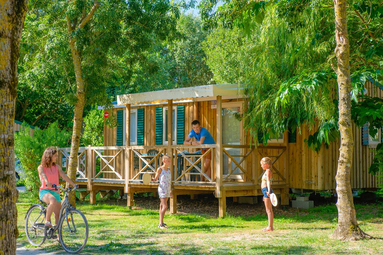 Holz-Mobilheim mit Terrasse, Familie und Fahrrad auf dem Campingplatz CAPFUN Huttes in Saint-Denis d'Ol�ron (17).