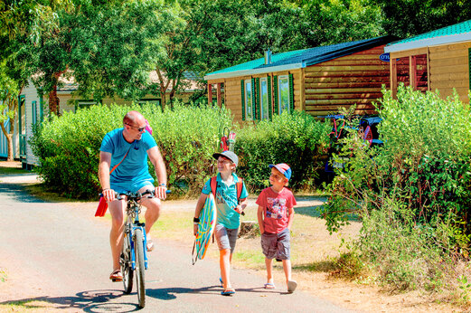 Familie auf Fahrrad, Mobilheime am Campingplatz CAPFUN Huttes in Saint-Denis d'Oléron.