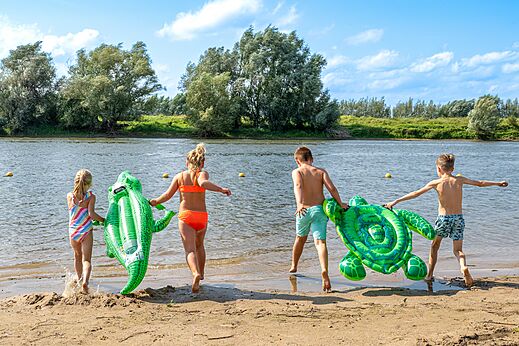 Kinder am Strand, aufblasbare Schwimmtiere, auf dem Campingplatz CAPFUN IJsselstrand in Doesburg.