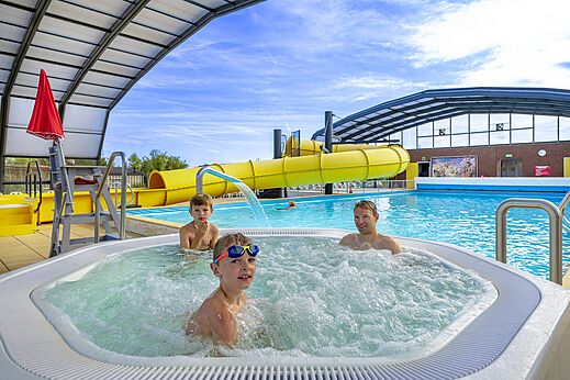 Bubbling jacuzzi, swimming pool and yellow slide at CAPFUN IJsselstrand campsite in Doesburg.