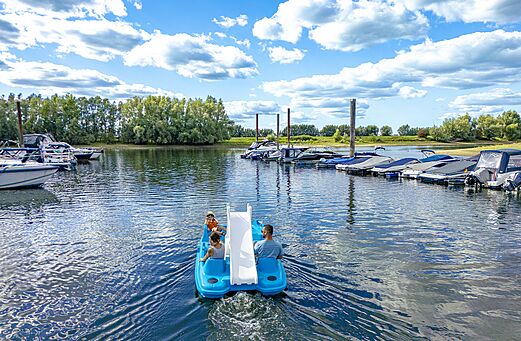 Tretboot mit Rutsche und Familie auf dem Wasser auf dem Campingplatz CAPFUN IJsselstrand in Doesburg.