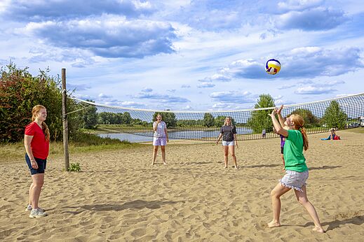 Volleyballspieler am Sandstrand auf dem Campingplatz CAPFUN IJsselstrand in Doesburg.