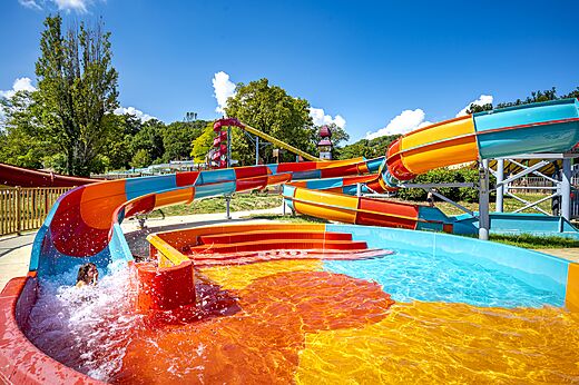 Bunte Wasserrutschen und Schwimmbad auf dem Campingplatz CAPFUN Imbours in LARNAS (07).