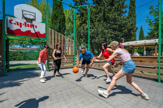 Multisportplatz mit Erwachsenen beim Basketballspielen auf dem Campingplatz CAPFUN Jantou in LE THOR (84).