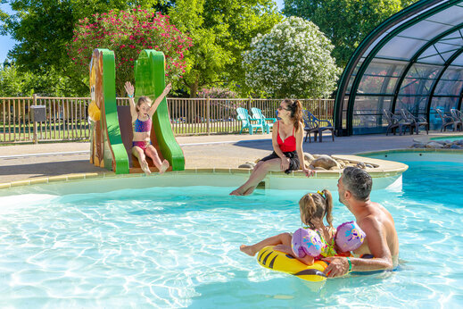 Toboggan enfant et famille s'amusant dans la piscine au camping CAPFUN Jantou à LE THOR (84).