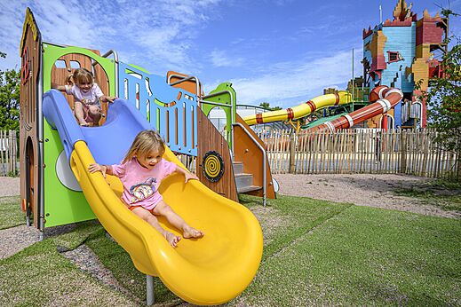 Enfants sur toboggans colorés, aire de jeux du camping CAPFUN Joncal.