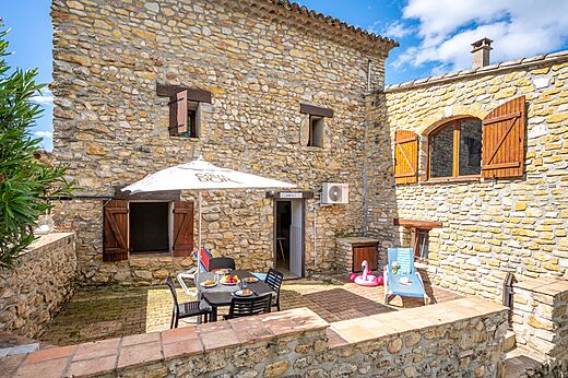Steingîte mit Terrasse und Tisch auf dem Campingplatz VAGUES OCEANES Labeiller in Saint Victor de Malcap (30).