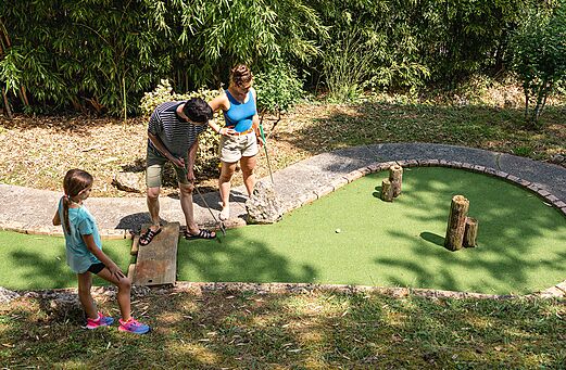 Familie spielt Minigolf auf grünem Platz auf dem Campingplatz CAPFUN Lac des 3 Vallées in Lectoure (32).