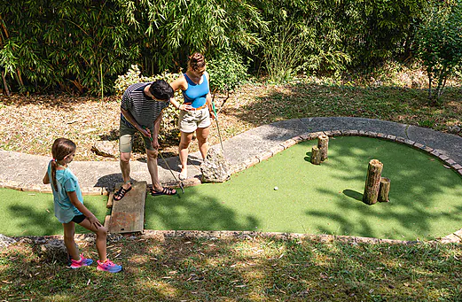 Famille jouant au mini-golf sur un parcours verdoyant au camping CAPFUN Lac des 3 Vall�es � Lectoure (32).