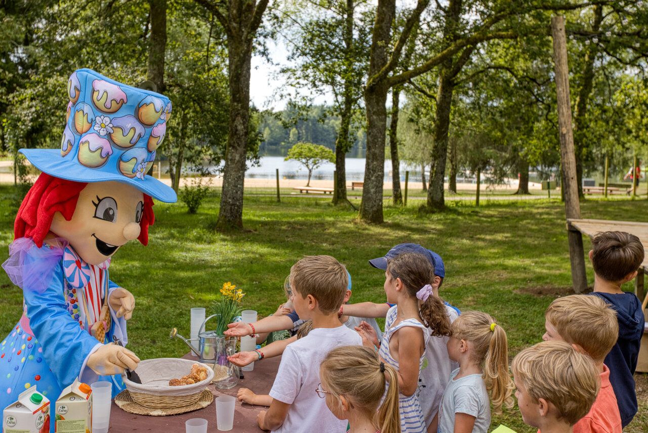 Mascota animando merienda infantil junto al lago, camping CLICOCHIC Lac de Miel.