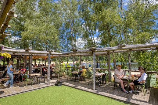 Schaduwrijk restaurantterras met gasten, op camping CLICOCHIC Lac de Miel in Beynat (19).
