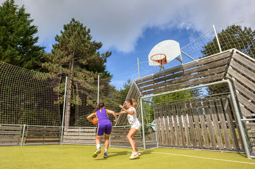 Twee vrouwen basketballen op multisportterrein op camping CLICOCHIC Lac de Miel in Beynat (19).