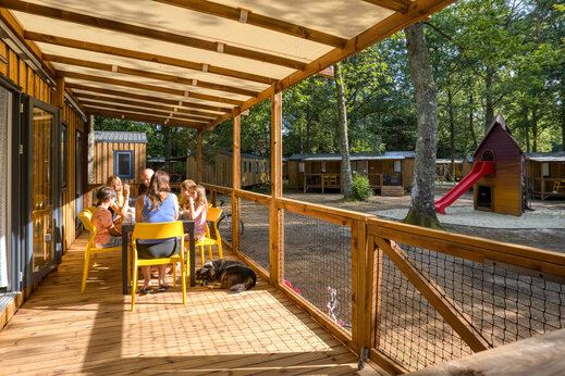 Familie op terras van Mobil-home op camping CLICOCHIC Lac de Miel in Beynat (19).