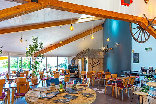 Ruim restaurantinterieur met tafels en stoelen op camping VAGUES OCEANES Lac de Panthier in Vandenesse-en-Auxois (21).