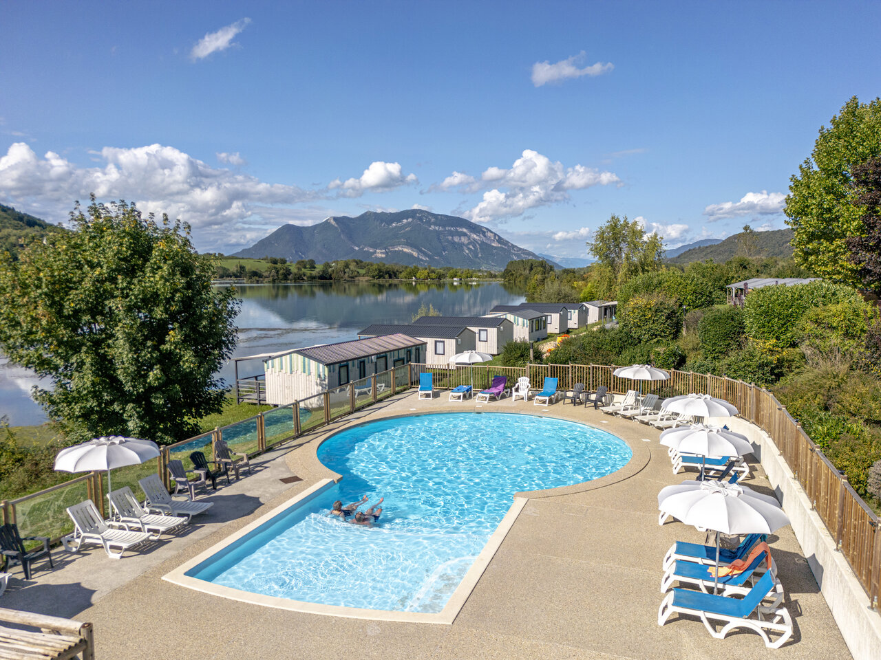 Piscine ext�rieure, transats, lac et mobil-homes au camping CLICOCHIC Lac du Lit du Roi � Massignieu-de-Rives (01).