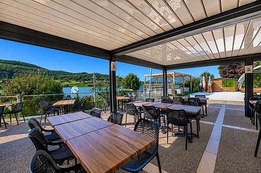 Restaurantterrasse mit Seeblick auf dem Campingplatz CLICOCHIC Massignieu-de-Rives (01).