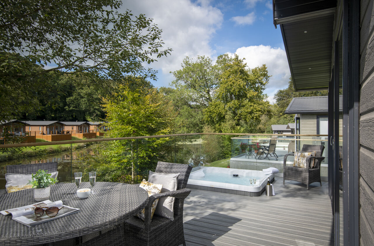 Terrasse mit Whirlpool und Holzchalets auf CAPFUN UK Lakeview Manor, Dunkeswell.