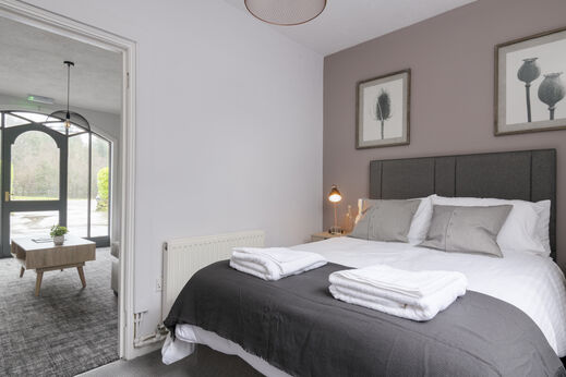 Komfortables Schlafzimmer mit gro�em Doppelbett und moderner Einrichtung auf dem Campingplatz CAPFUN UK Lakeview Manor in Dunkeswell.