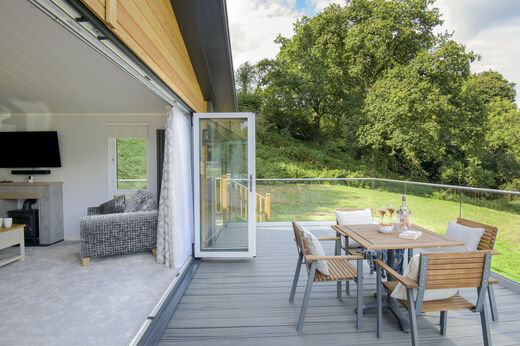 M�blierte Terrasse und Wohnzimmer einer Unterkunft auf dem Campingplatz CAPFUN UK Lakeview Manor in Dunkeswell.