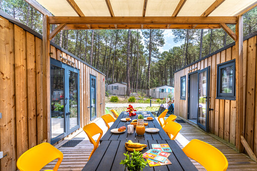 Außenterrasse mit Frühstück und modernem Mobilheim auf dem Campingplatz CAPFUN Landisland in Moliets-et-Maa (40).