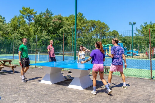 Freunde spielen Tischtennis im Freien auf Campingplatz CAPFUN Landisland Moliets-et-Maa.