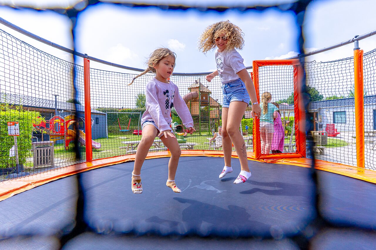 Kinder auf Trampolin, Spielplatz im Camping VAGUES OCEANES Les Iles in Hudimesnil (50).