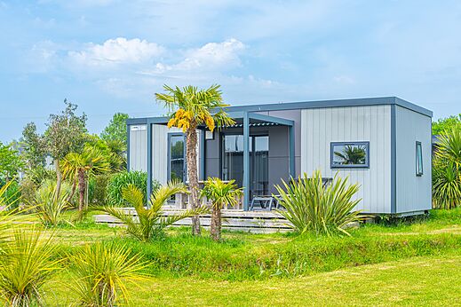 Modern stacaravan met terras, palmbomen op camping VAGUES OCEANES Les Iles in Hudimesnil.