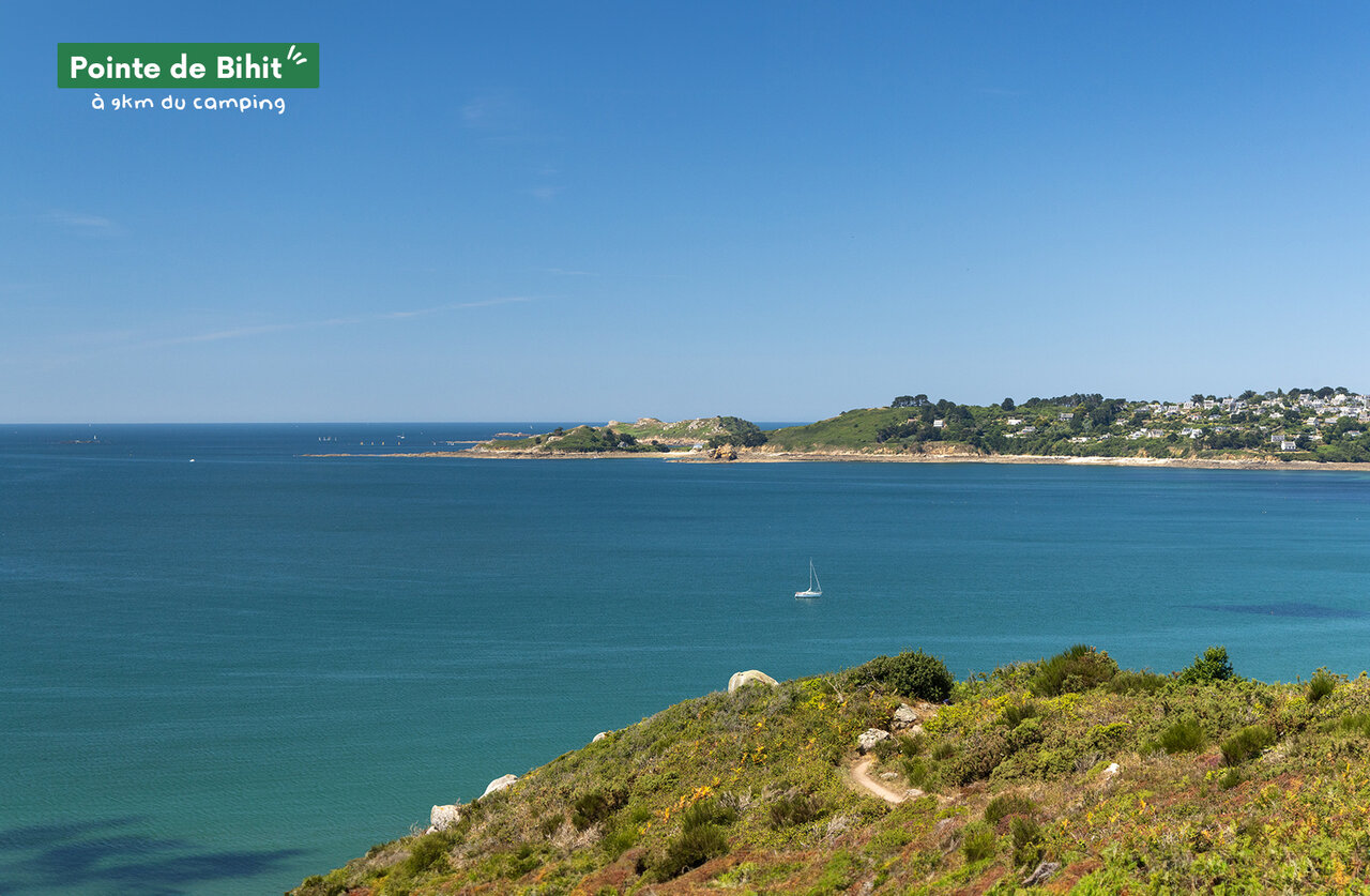 Pointe de Bihit, kustlandschap met turquoise zee en zeilboot, nabij Lannion, Bretagne.