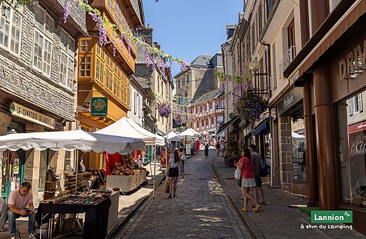Belebte Einkaufsstraße mit Kunsthandwerksmarkt in der Altstadt von Lannion, Bretagne.