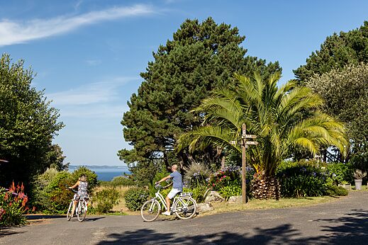 Radfahrer auf grünem Weg mit Meerblick auf dem Campingplatz CLICOCHIC Les plages de Beg Léguer in Lannion (22).