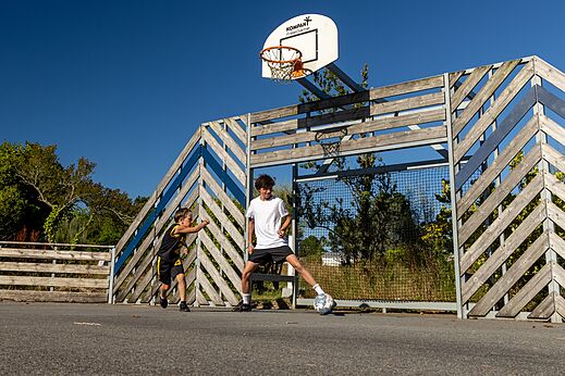 Kinder spielen Fußball auf Multisportplatz auf dem Campingplatz CLICOCHIC in Lannion.