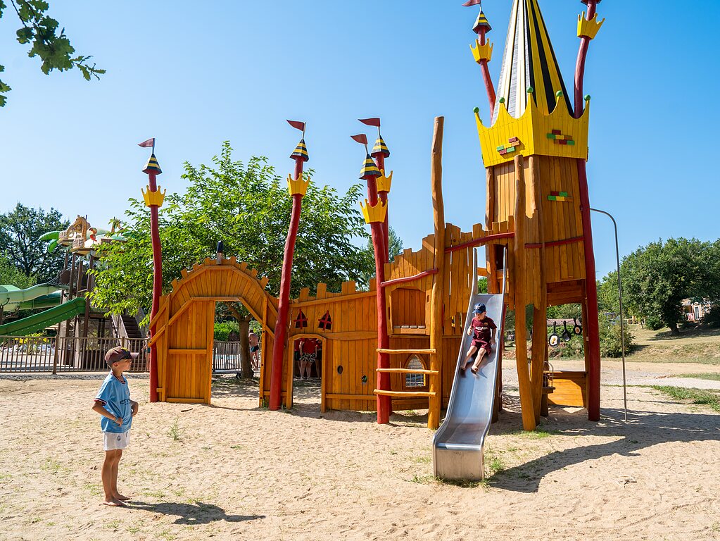 Holzschloss-Spielplatz, Rutsche, Kinder auf dem Campingplatz CLICOCHIC in Padirac.