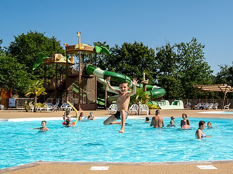 Kind springt in Pool mit Rutschen auf Campingplatz CLICOCHIC Les Secrets de Padirac.