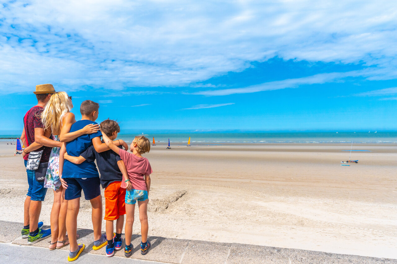 Familie beobachtet Strandsegler am Strand auf dem Campingplatz VAGUES OCEANES Licorne in Dunkerque (59).