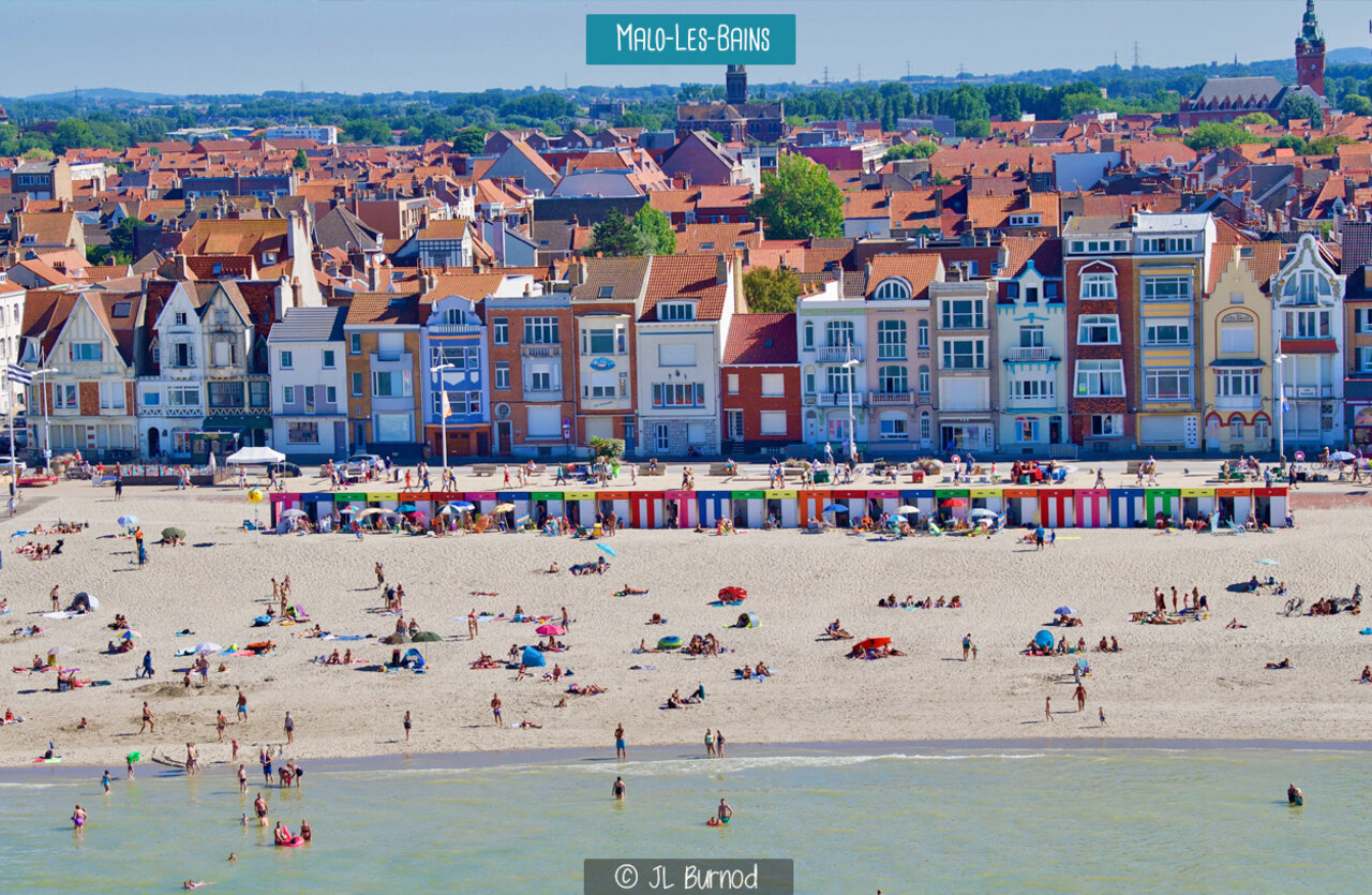 Strand von Malo-les-Bains mit bunten Strandkabinen und Stadt Dunkerque.