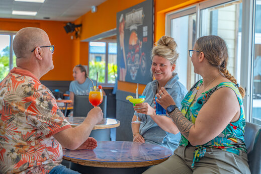 Clients souriants avec cocktails au bar du camping VAGUES OCEANES Licorne à Dunkerque (59).