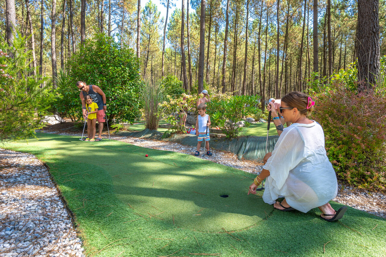 Family mini-golf course shaded by pine trees at CAPFUN Lila campsite in LINXE (40).