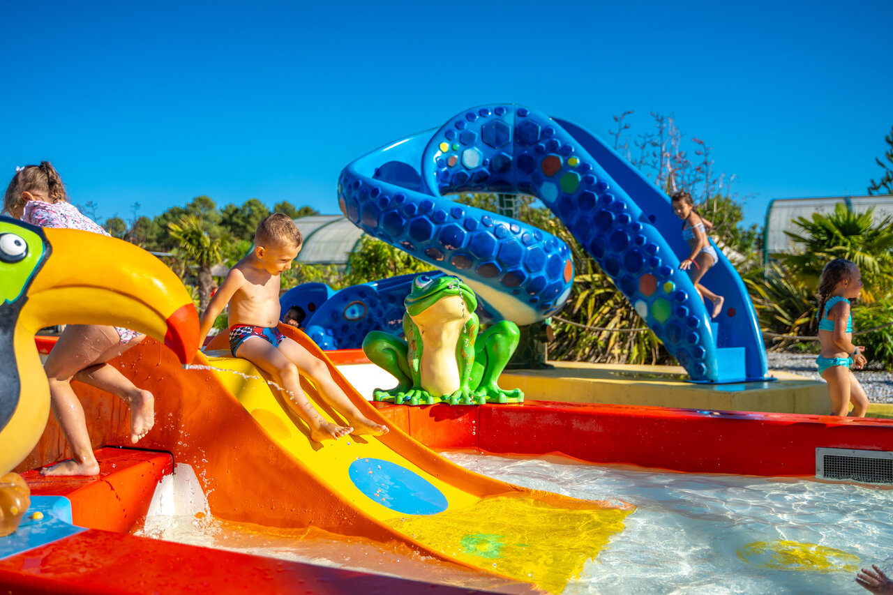 Children playing on colorful slides and water games, splash pad at CAPFUN Lila campsite in LINXE (40).