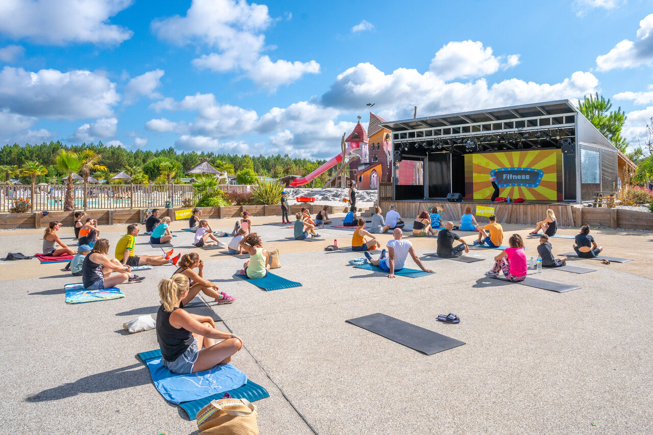 Outdoor fitness class on stage, participants, CAPFUN Lila campsite in LINXE (40).
