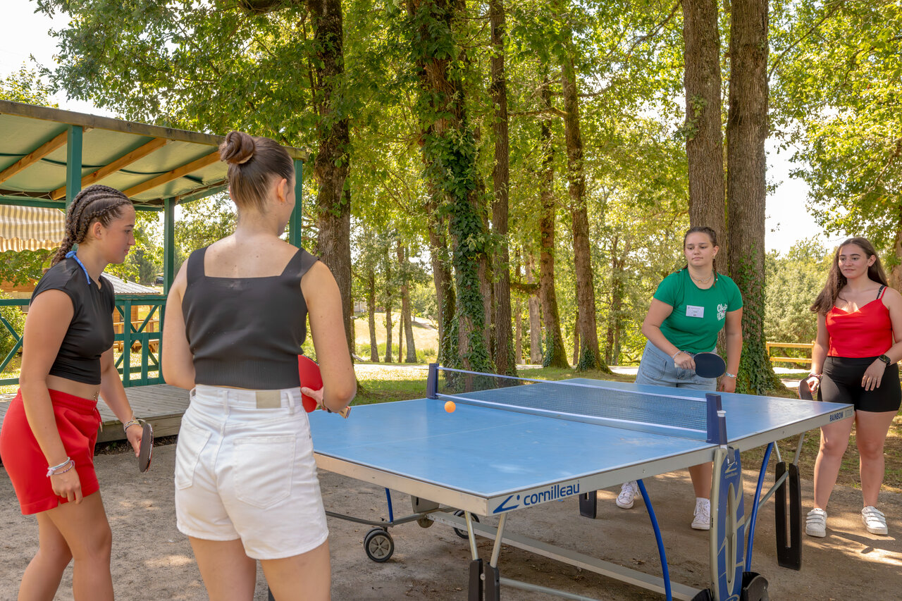 Young people playing table tennis outdoors, entertainment at CLICOCHIC Linotte campsite in Le Bugue (24).