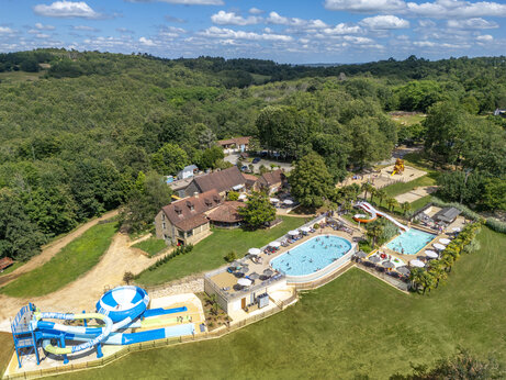 Luftaufnahme des Wasserparks mit Pools, Rutschen und Spielplatz auf dem Campingplatz CLICOCHIC Linotte in Le Bugue (24).