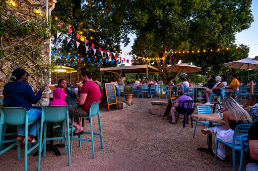 Belebte Restaurant- und Bartrasse am Abend auf dem Campingplatz CLICOCHIC Linotte in Le Bugue.