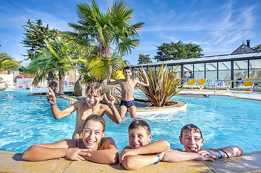Lachende Kinder und Jugendliche im Außenpool auf dem Campingplatz CLICOCHIC Longchamp in Saint Lunaire (35).