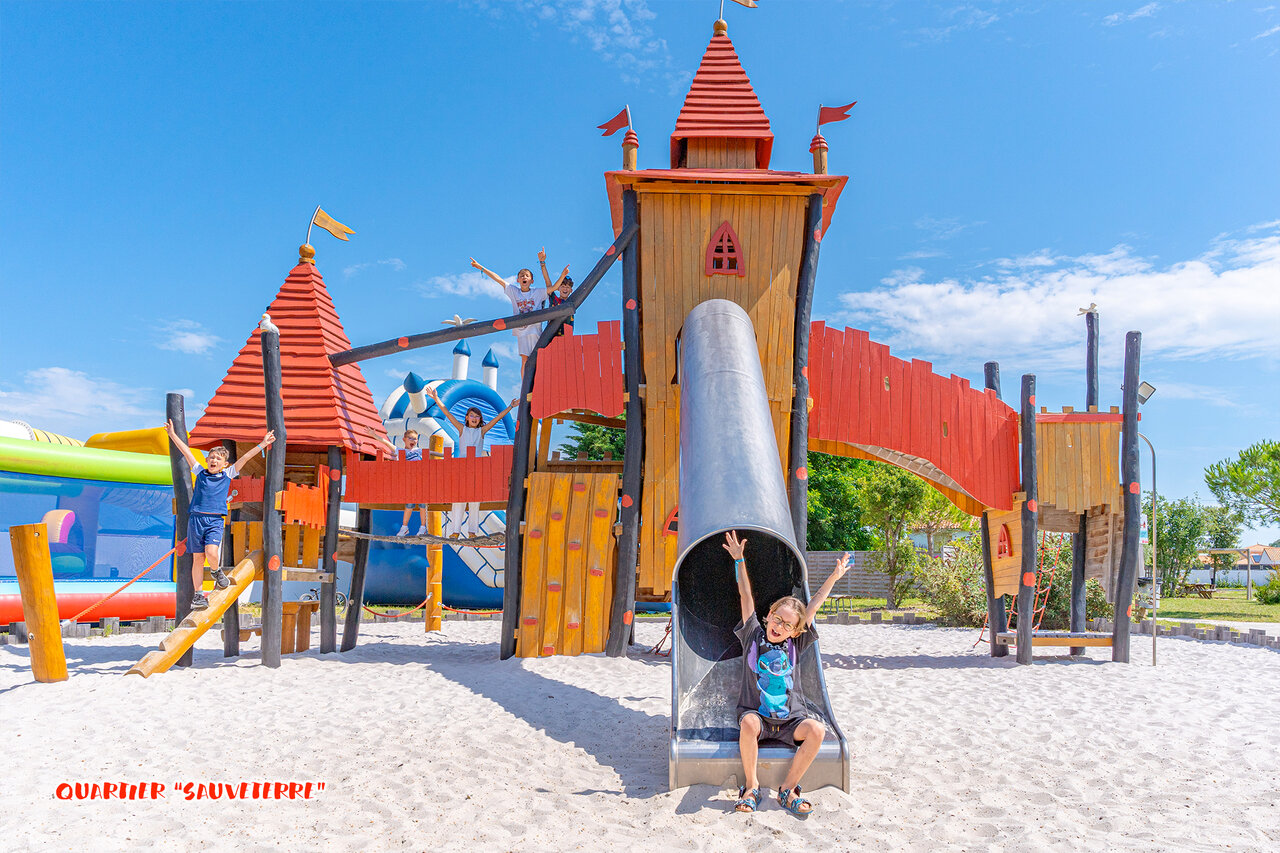 Kinder spielen auf dem Holzspielschloss auf dem Campingplatz CAPFUN Loubine in Les Sables d'Olonne.