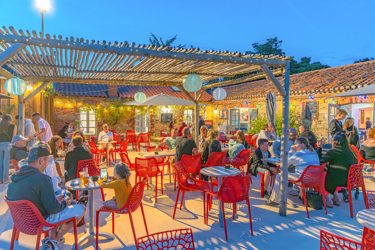 Belebte Restaurant-Bar-Terrasse, beleuchtete Pergola, Camping CAPFUN Loubine Les Sables d'Olonne.