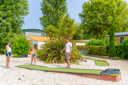 Minigolf mit Familie spielend auf grünem Platz auf dem Campingplatz CAPFUN Loubine in Les Sables d'Olonne (85).