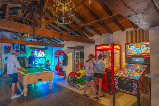 Spielzimmer mit Billard und Arcade-Automaten auf dem Campingplatz CAPFUN Loubine.